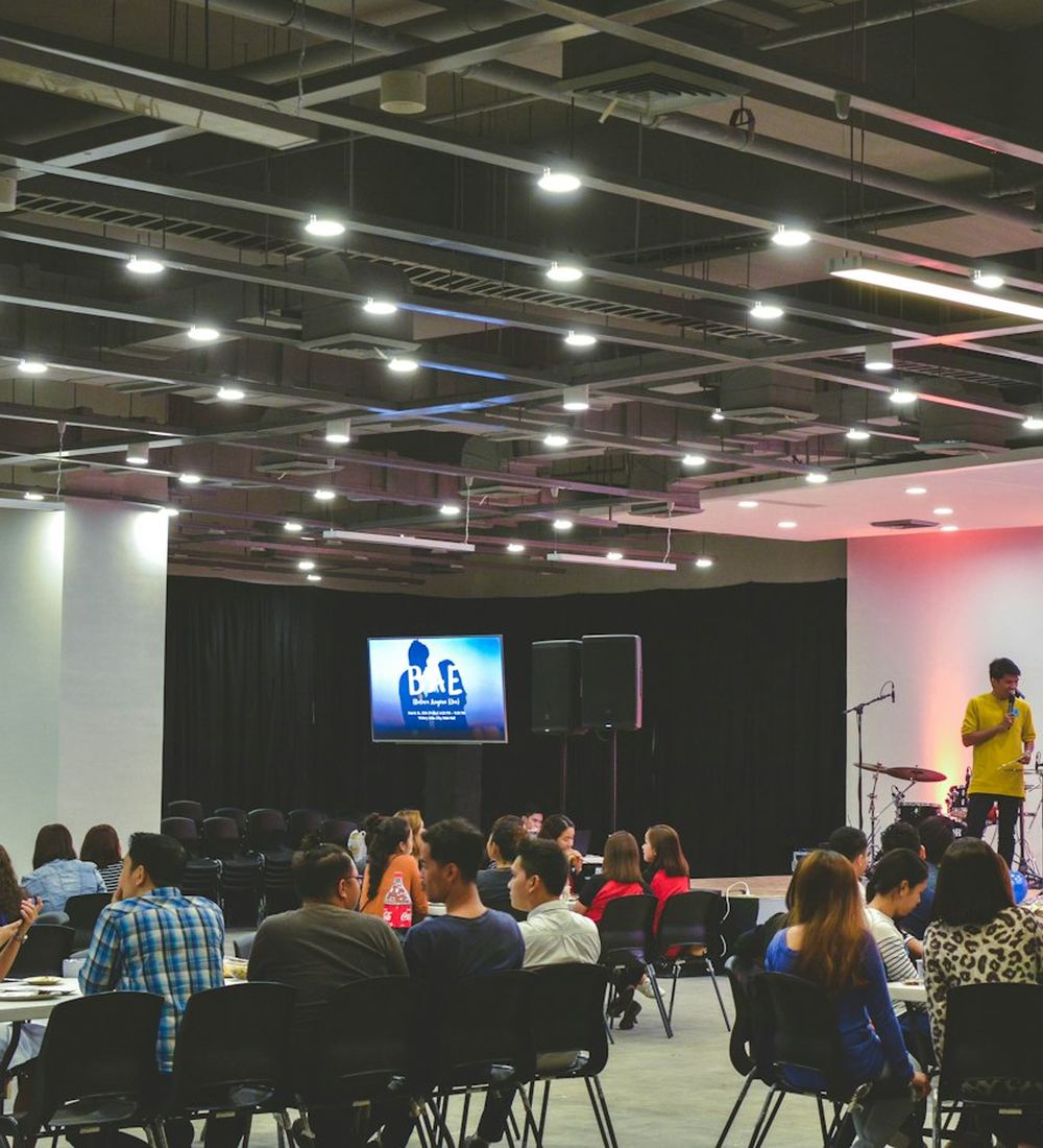 A corporate event hall with an audience watching a presentation